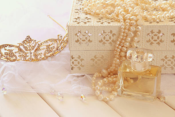 istock White pearls necklace, diamond tiara and perfume bottle 608640606