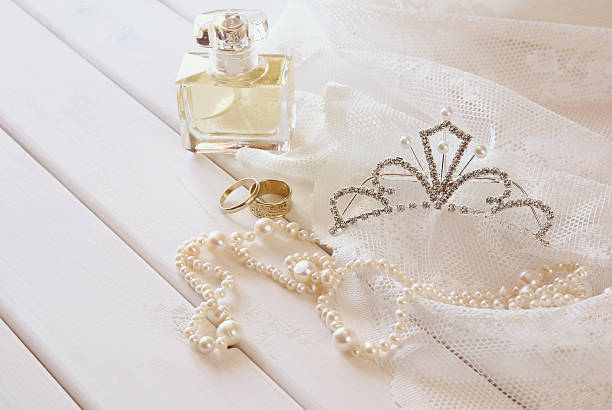 istock White pearls necklace, diamond tiara and perfume bottle 608640736