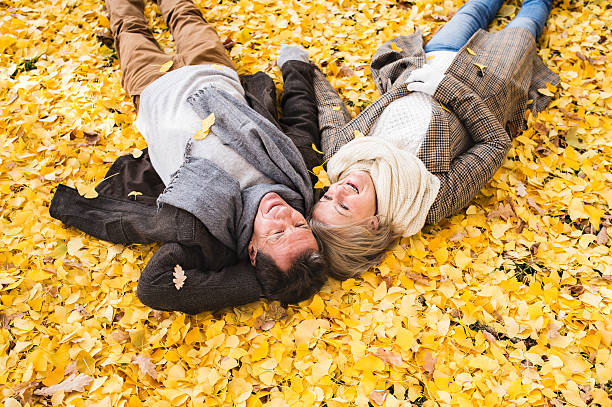 istock Active senior couple in autumn park lying on the ground 609032818