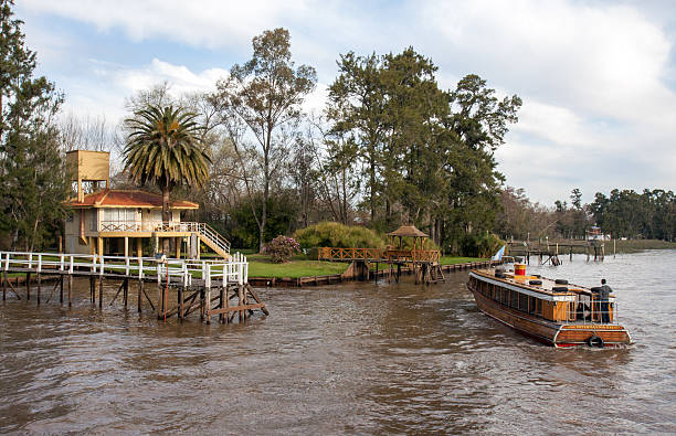 El Tigre, Buenos Aires, Argentina - August 11, 2014: bus boat mooring near house on poles along the Rio San Antonio in the Parana delta.