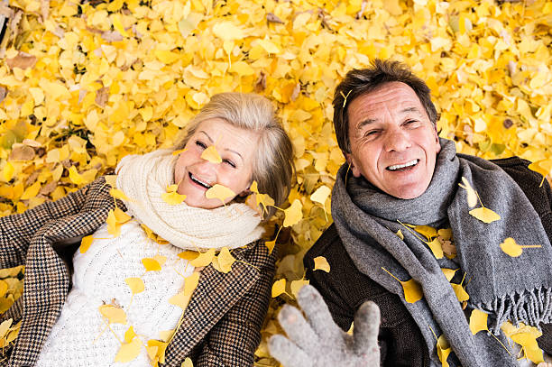 istock Active senior couple in autumn park lying on the ground 609032914