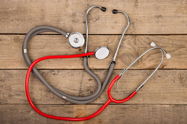 istock Grey and red stethoscopes on wooden desk 609033876