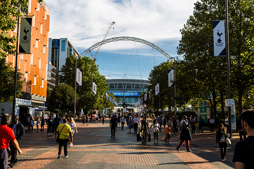 London, UK - September 14, 2016: supporters of Tottenham Hotspur FC wait on Wembley Way, outside Wembley Stadium (the national stadium of England) in preparation for their team's Champions League match versus Monaco. Many of the fans are decked out in Tottenham's famous white kit.