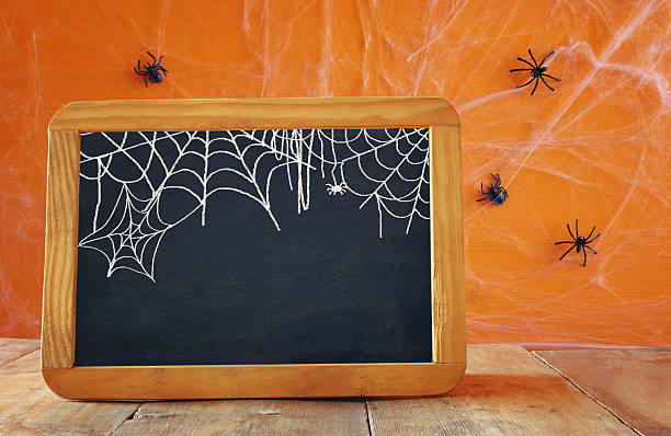 istock Empty blackboard on wooden table. Halloween concept 609034924