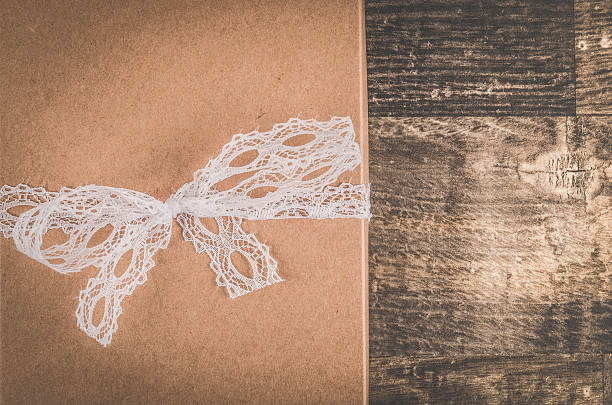 istock Lovely brown gift with a beautiful white ribbon on table 609037468