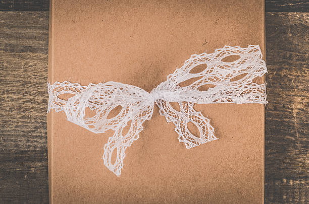 istock Lovely brown gift with a beautiful white ribbon on table 609038640