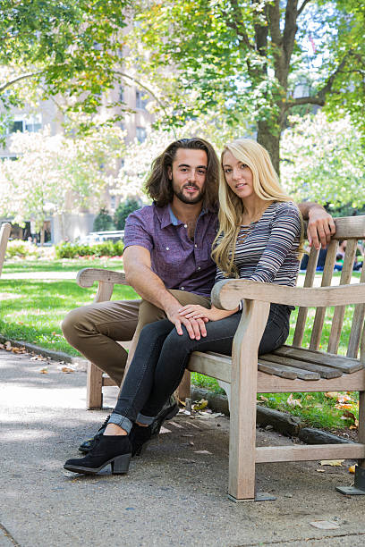 istock Young Couple sitting on a Park Bench 609042720