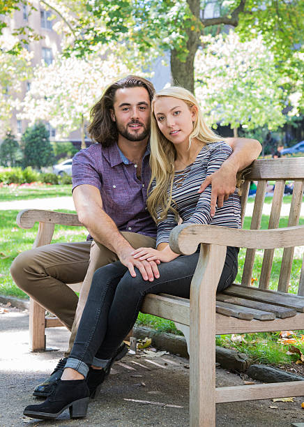 istock Young Couple sitting on a Park Bench 609042780