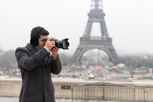 Photographer in front of Eiffel Tower in city of Paris, FRANCE