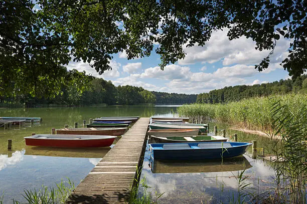 Rowboats on a jetty at lake Roofensee in the eastern part of Germany, Europe, in summer