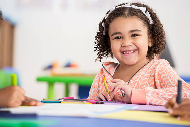 istock Smiling preschool girl has fun in her class 609050076