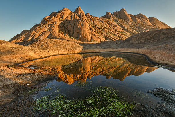 istock granite monolith reflected in pool of clear water 609051362