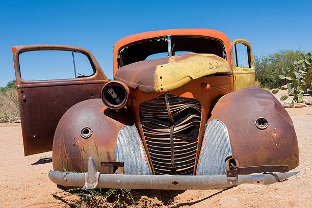 a shell of an old colorful rustic car abandoned in the desert.
