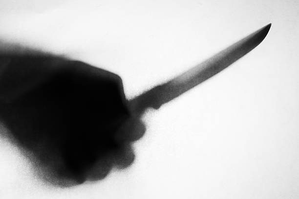 shadow of hand holding knife stabbing someone, soft focus, blurred