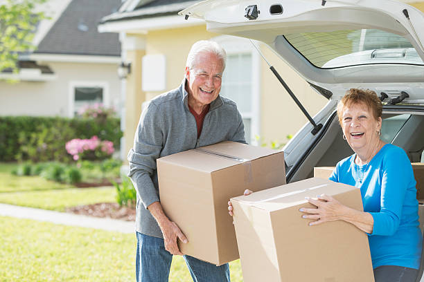 feliz casal sénior movendo caixas de aluguer - downsizing imagens e fotografias de stock