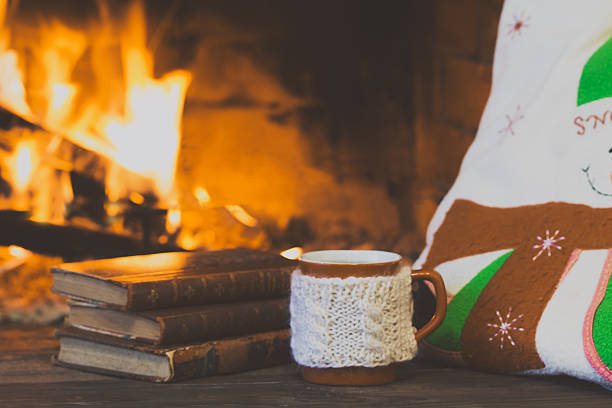 istock Antique books, tea, pillow, fireplace as background. Christmas, winter concept 609054366