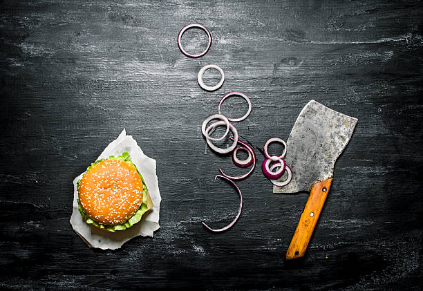 istock Burger with onion rings and an old hatchet.  Top view. 609055370