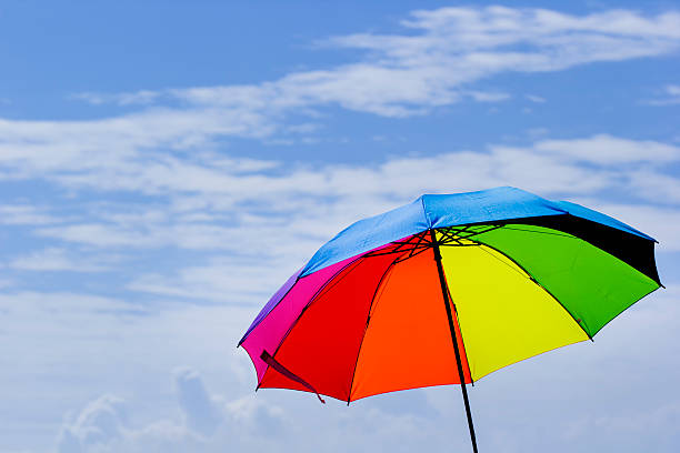 istock Beautiful Rainbow umbrella on bright sky background. 609055656