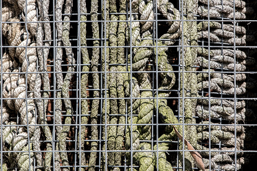 An abstract selection of caged rope patterns. This is actually a manmade home for insects otherwise known as an insect hotel.