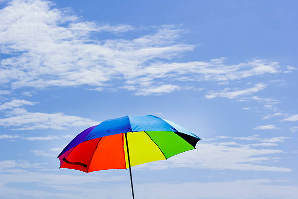 istock Beautiful Rainbow umbrella on bright sky background. 609055880