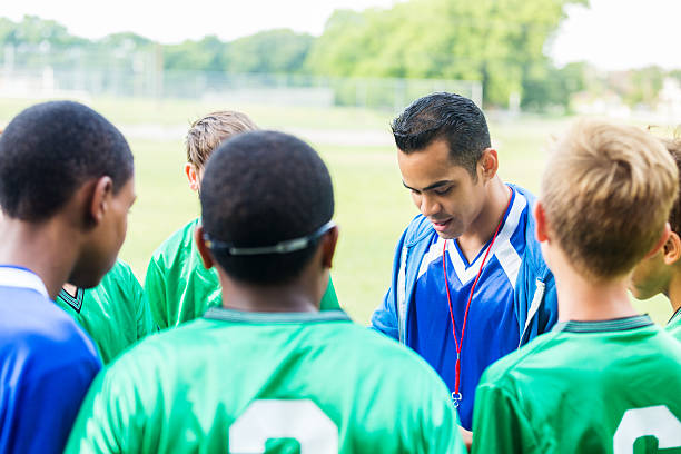istock Focused soccer coach instructs team during time out 609056766