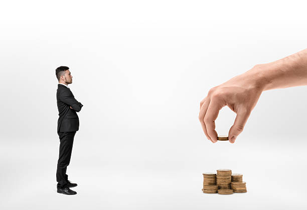 istock Businessman looking at big man's hand making stacks of 609056906