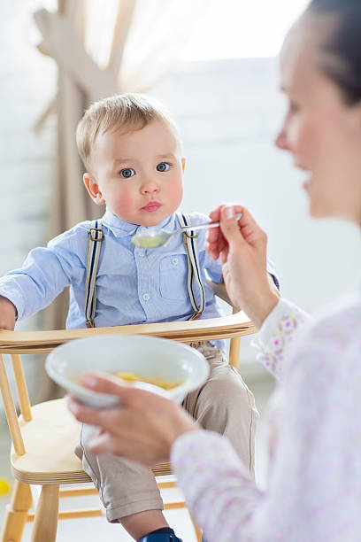 istock Beautiful young woman feeds her baby son 609057806