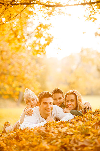 istock Happy family lying in autumn leaves 609060326