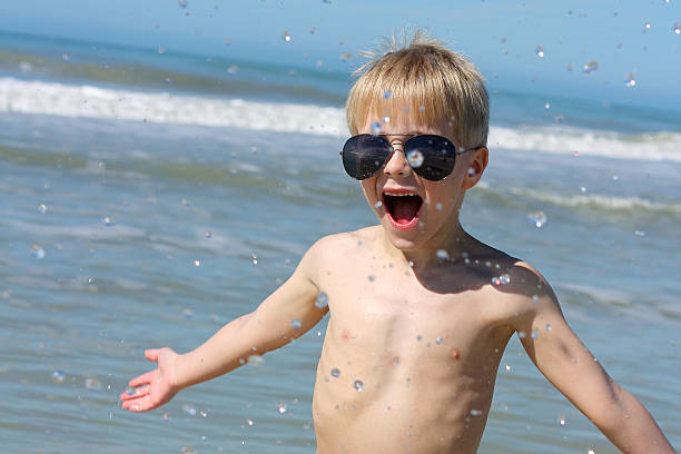 istock Happy Young Child Playing in the Ocean 609060560
