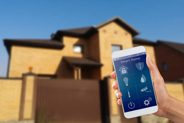 Smartphone with home security app in a hand stock photo