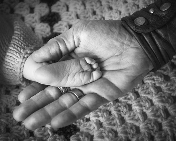 istock Baby Foot in Fathers Hand 609072530