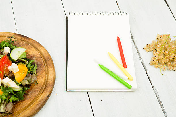 istock salad of fresh vegetables and a blank notebook 609072736