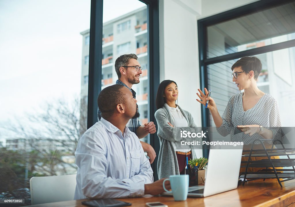 She's bringing some of her bright ideas to the front Cropped shot of a group of colleagues having a discussion in a modern office Teamwork Stock Photo