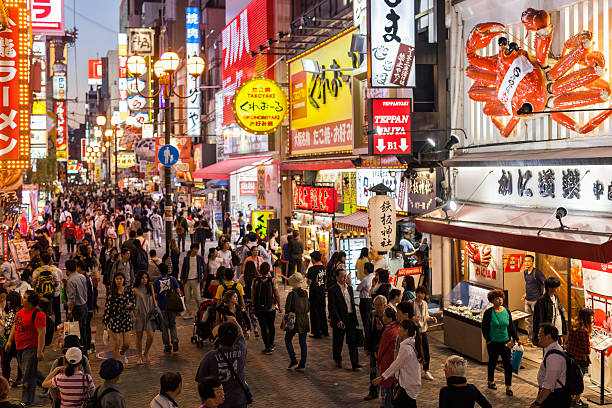 Dotonbori Street, Osaka, Japan People walking  on thefamous Dotonburi shopping street in Osaka, Japan. osaka city photos stock pictures, royalty-free photos & images