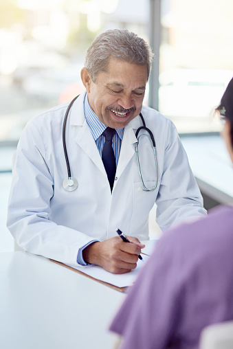 Cropped shot of a male doctor talking to a patient in his office
