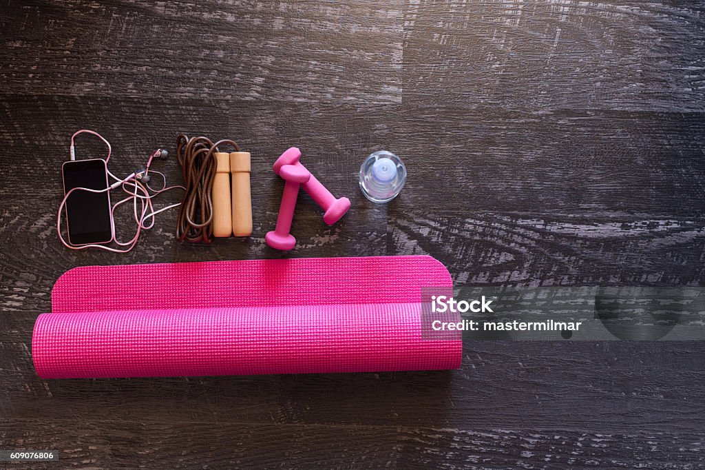 Équipement de fitness femme et tapis de yoga rose sur fond de bois - Photo de Accessoire libre de droits