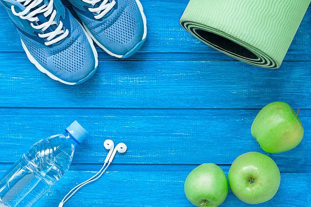 flache sportschuhe, wasserflasche, matte und kopfhörer - weights dieting apple healthy eating stock-fotos und bilder