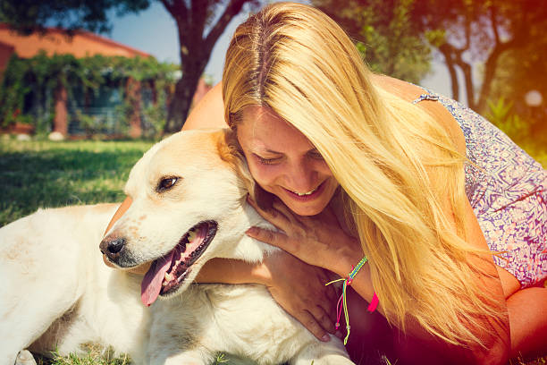 istock Beautiful blonde woman hugging her dog 609081120