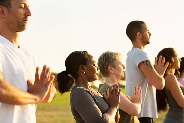 gruppo che esercita yoga all'aperto al tramonto - fourty five foto e immagini stock