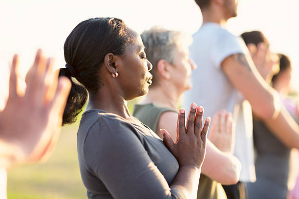 istock Group exercising Yoga outdoors at sunset 609081390