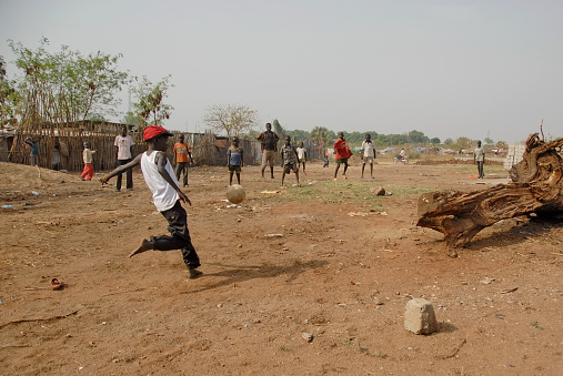 Juba, South Sudan - February 26th, 2012: Unidentified kids play soccer on a street of Juba on February 26, 2012 in Juba, South Sudan. 