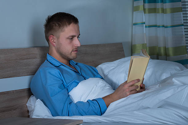 istock Man Reading Book In His Bedroom 609081776