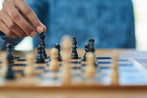 Shot of an unidentifiable man moving a chess piece