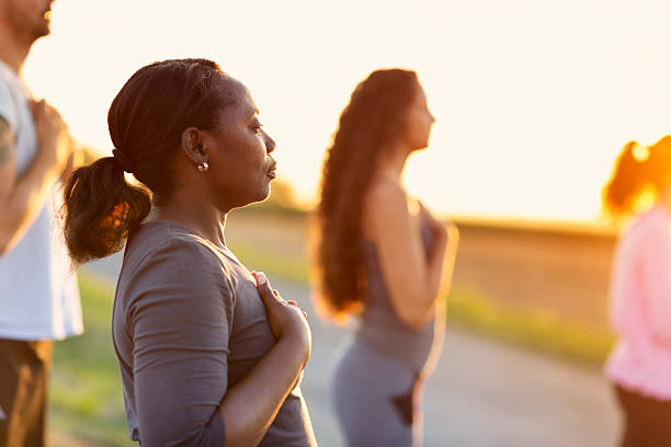 Group exercising Yoga outdoors at sunset
