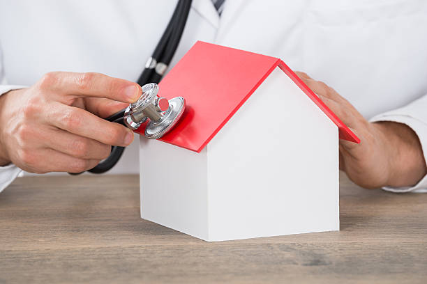 istock Doctor Hand Holding Stethoscope On House Model 609083664