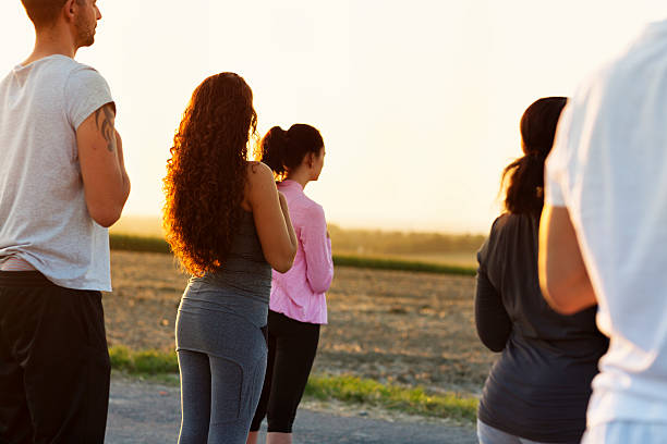 istock Group exercising Yoga outdoors at sunset 609083798
