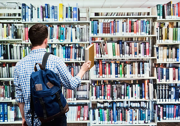 istock Rear view of student standing in library 609086406