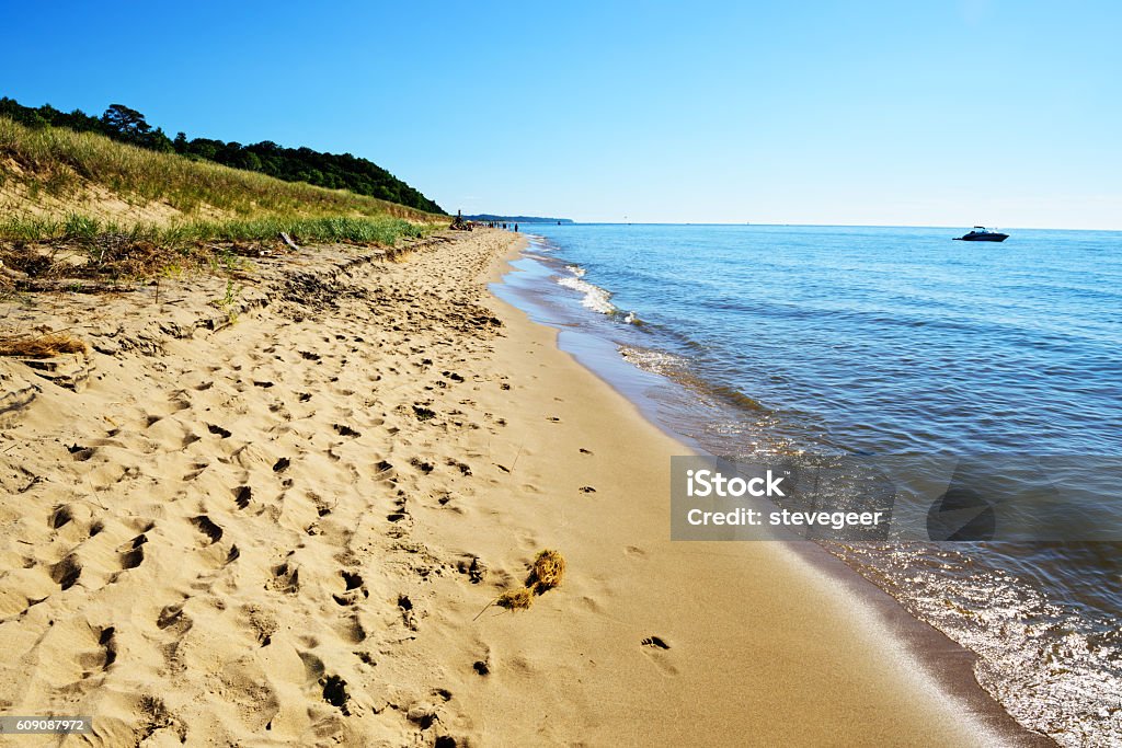 Lake Michigan beach, Saugatuck Dunes State Park Sandy shore of Lake Michigan at Saugatuck Dunes State Park in Allegan County, Michigan. Distant people and moored boat. Michigan Stock Photo