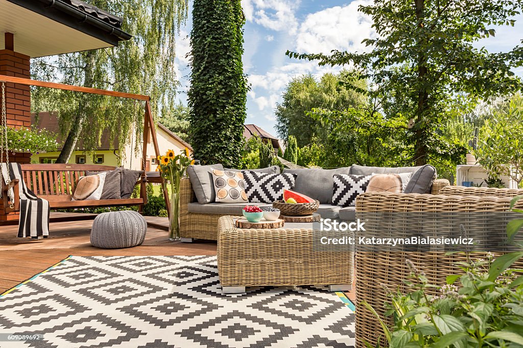 New villa patio idea New design villa patio with comfortable rattan furniture and pattern carpet Patio Stock Photo
