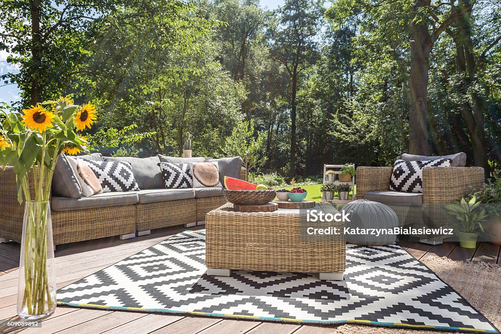 Outdoor relax in luxurious style Villa patio with stylish rattan furniture and pattern carpet Outdoors Stock Photo